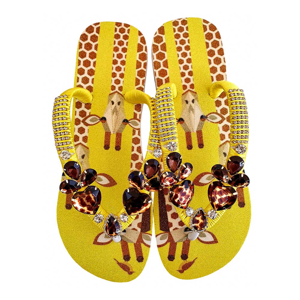 Chanclas Havaianas decoradas con un estampado de jirafas y tiras con pedrería en tonos ámbar.