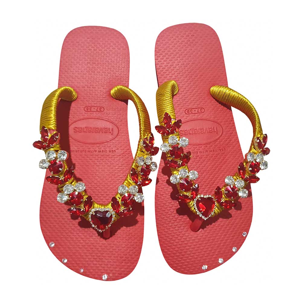 Chanclas Havaianas en rojo coral con tiras doradas decoradas con pedrería.
