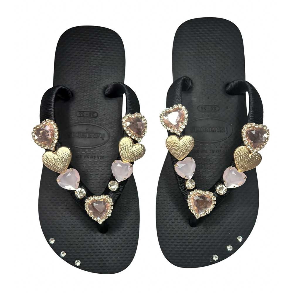 Chanclas Havaianas color negro adornadas con corazones dorados.
