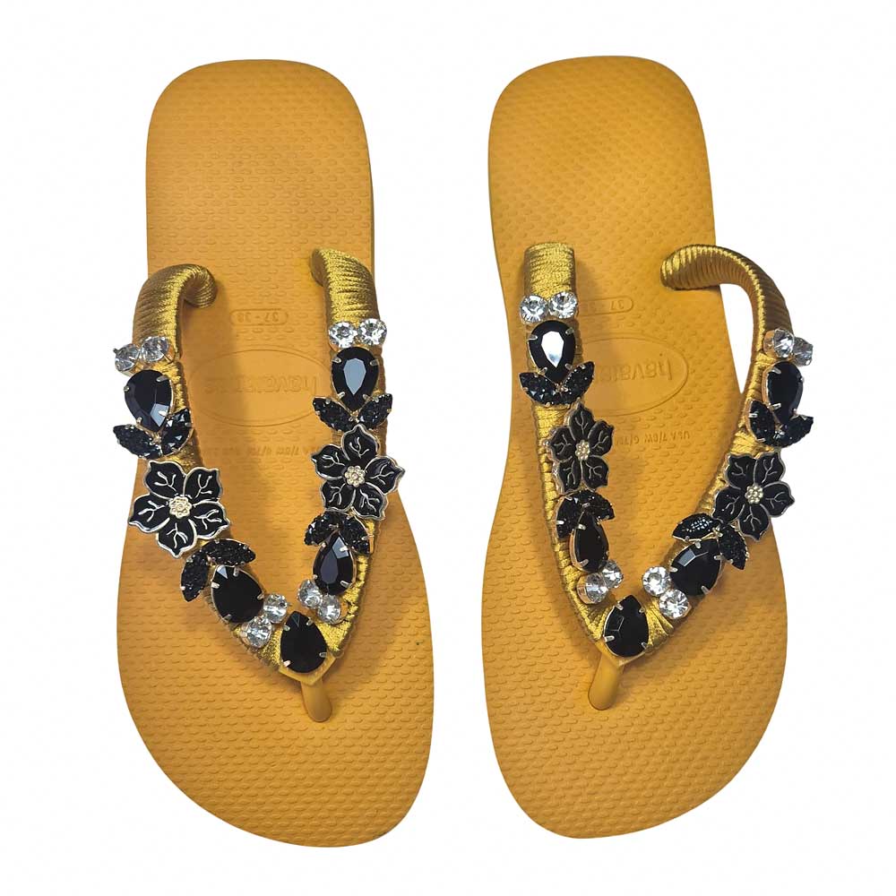 Chanclas Havaianas en color mostaza decoradas con cristales y flores negras.