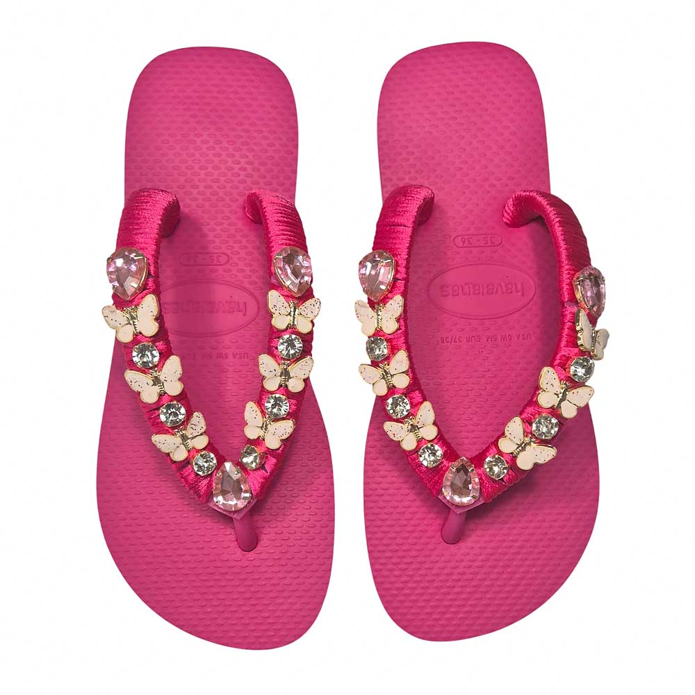 Chanclas Havaianas con base rosa, adornadas con pequeñas mariposas,
